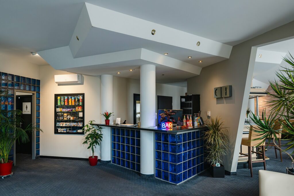 Rezeption mit dahinterliegender Hotelbar und Ausgang zum Gartenbereich
